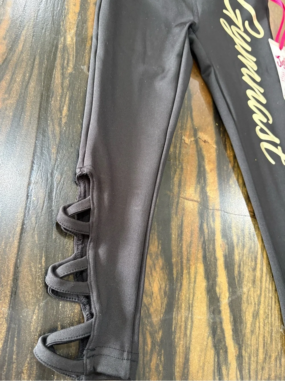 Justice Black Leggings with Pale Gold 'Gymnast' Script and Side Loop Detail